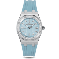 The Celeste - Sky Allure wristwatch featuring a light blue dial with textured detailing, cubic zirconia hour markers and bezel, silver-toned case, and matching blue silicone strap, bold by design.