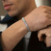 Close up wrist with silver iced bracelet on, with a blurry background