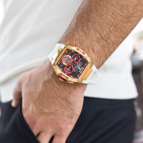 The Intrepid Sport - Ice White men's luxury watch featuring a bold rose gold-tone case, black and red dial with chronograph subdials, and a white strap, worn on wrist.
