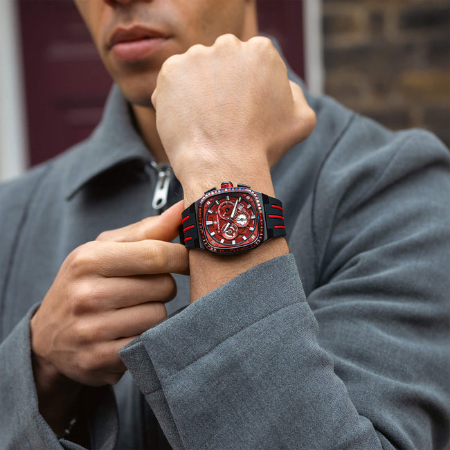 A man wearing The Legacy Chrono Ice - Midnight Ruby, a bold men's luxury watch with a red chronograph dial, black case, ice-set bezel, and black strap with red accents, bold by design.