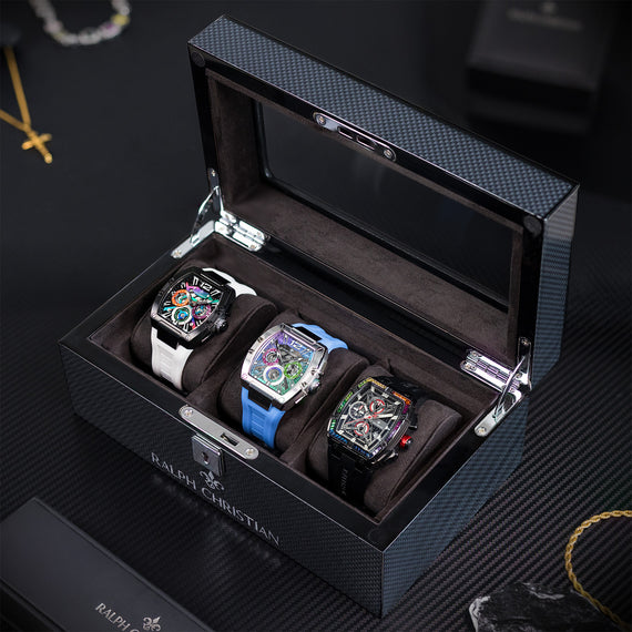 Luxury Collectors Watch Case displaying three automatic chronograph watches with colorful dials and leather straps, set on a sleek textured surface in a stylish lifestyle setting.