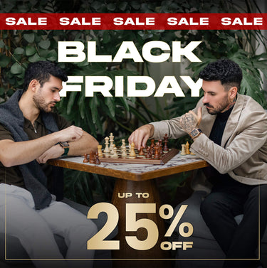 Two men sitting at a table outdoors with a magazine on the table.