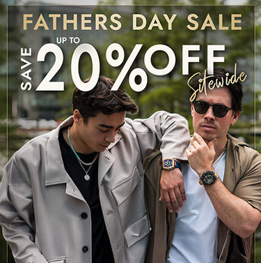 Two men outdoors wearing stylish watches and casual jackets, one with dark hair looking down and the other wearing sunglasses looking forward, with a green natural background and a bold red 