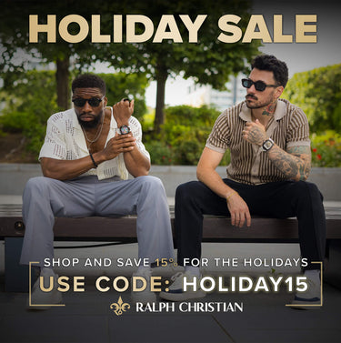 Two men sitting at a table outdoors with a magazine on the table.