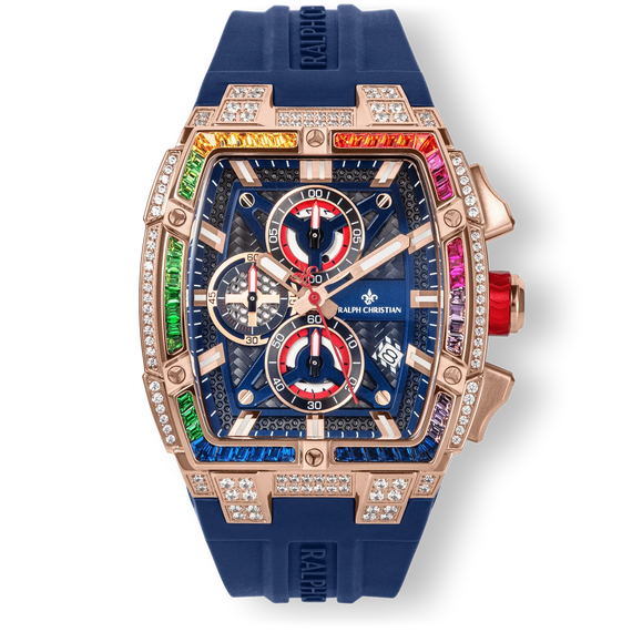 The Polaris Chrono Ice - Celestial Nova men's luxury watch features a rose gold-tone case with a rainbow gradient of cubic zirconia stones set on the bezel, a deep blue textured dial with red and white chronograph subdials, date function, and a blue silicone strap, combining bold design and statement watch craftsmanship.