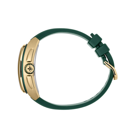 A close-up rear view of a watch with a dark green silicone strap and a gold-tone case, featuring a crown guard and a circular logo medallion on the side.