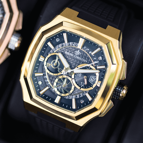 Luxury watch with gold case and black dial on a dark background