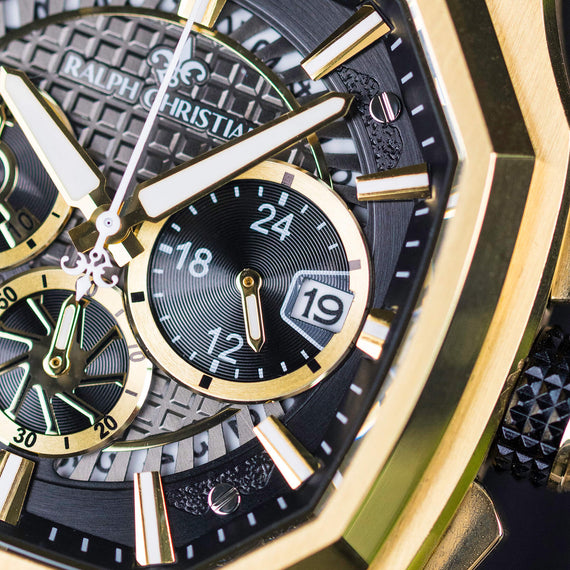 Close-up of a Ralph Christian watch with gold and black design