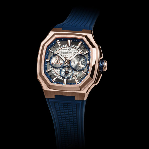 Luxury watch with blue strap and rose gold case on black background
