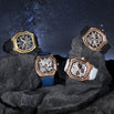 Four ornate watches on rocks with a starry night sky background