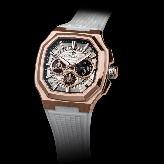 Luxury watch with rose gold case and white strap on black background