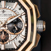 Luxury watch with rose gold case and detailed face on a dark background
