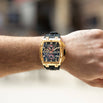 The Polaris Chrono - Obsidian Black men's luxury watch with a bold gold-tone case, black dial featuring chronograph subdials, and a black rubber strap, worn on wrist.