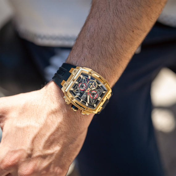 The Polaris Chrono - Obsidian Black men's luxury watch with a bold gold case, black dial featuring chronograph subdials, and a black strap, worn on wrist in a lifestyle setting.